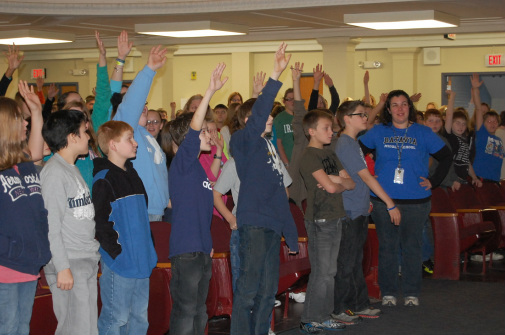 Students raising their hands in response to Andy's presentation
